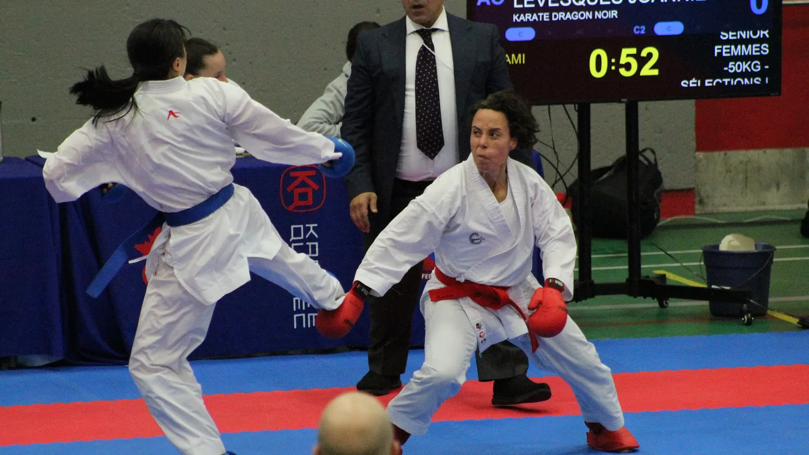 Combattants de karaté face à face sur un tatami pendant un tournoi